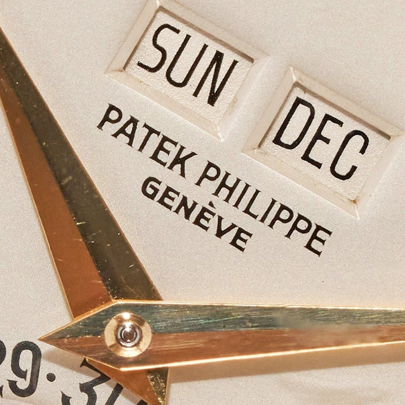 Close-up of a Patek Philippe watch with gold accents and text.